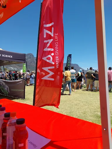 MANZI Water Giving Life banner at a local outdoor event